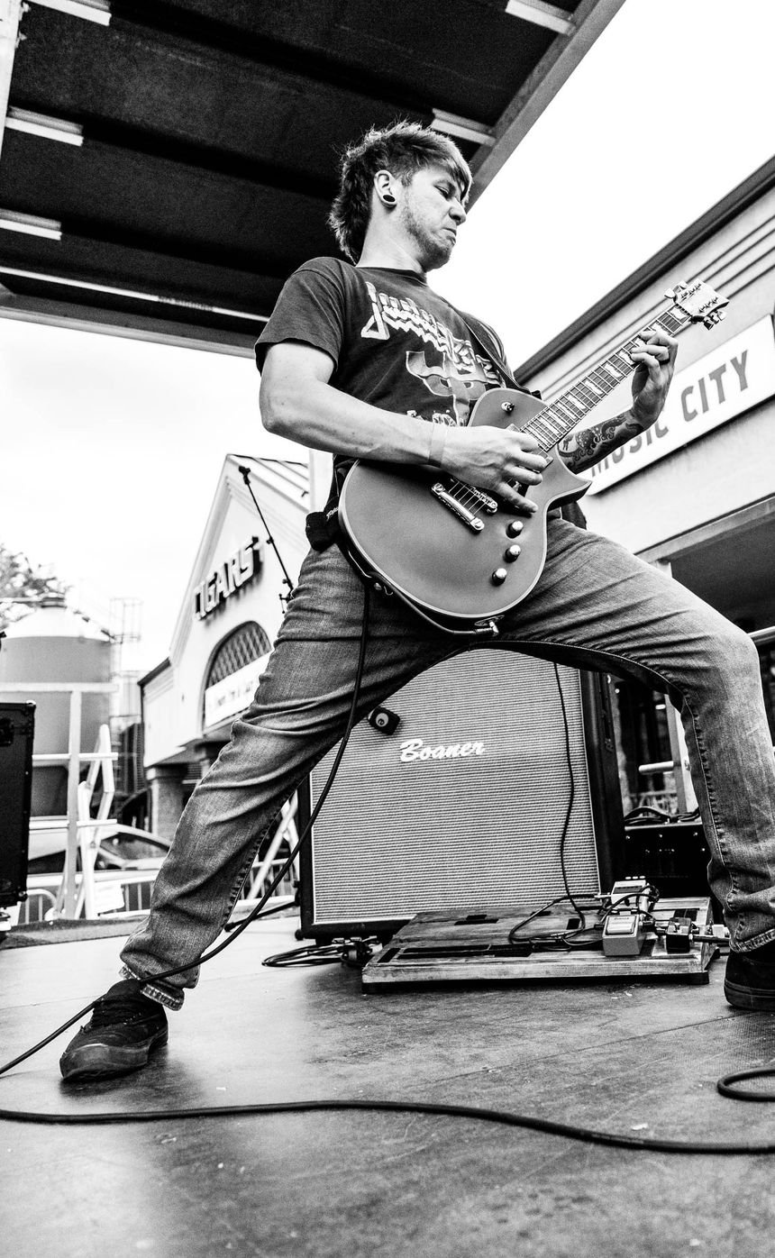 Amped Up Dad on stage, mid-riff in front of the amp and pedalboard